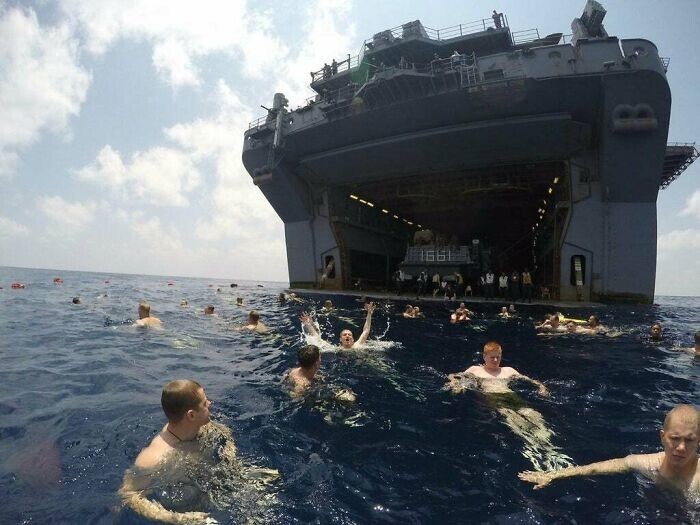 24. Военные плавают рядом с кораблем в открытом океане, в километрах от суши