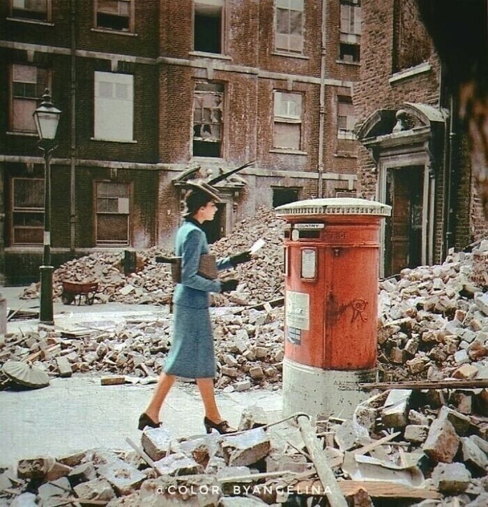 25. Женщина идёт с письмом к почтовому ящику среди разрушенных зданий и завалов, вызванных немецкими воздушными налетами во время Второй мировой войны. Лондон, 1940 год