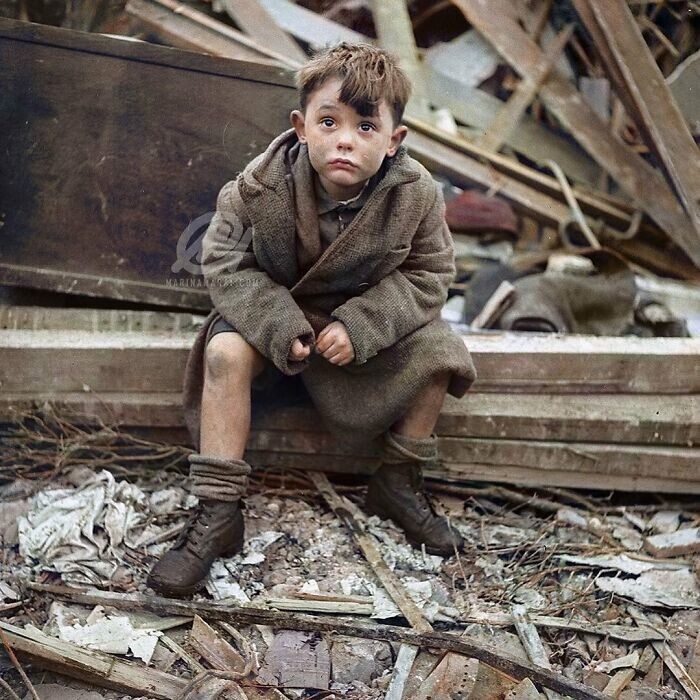 27. Мальчик сидит среди развалин после бомбардировки Лондона во время Второй мировой войны. Фотография сделана в январе 1945 года