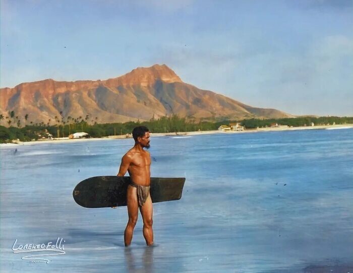 14. Гавайский серфер, Чарльз Кауха, несет алайю, доску для серфинга, которую использовали на Гавайях до 20-го века, на пляже Вайкики в 1898 году