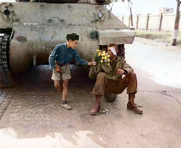 12. Маленький итальянец дарит цветы американскому солдату, чей танк остановился на окраине Рима, июнь 1944 года