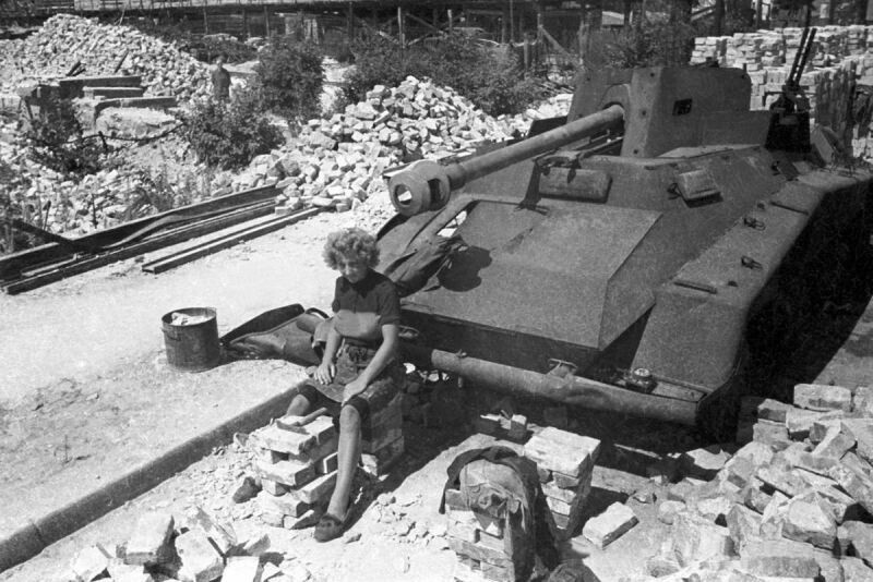 Женщина у подбитого немецкого тяжелого бронеавтомобиля Sd.Kfz. 234/4 с 75-мм противотанковой пушкой Pak 40/2 L/46 (таких машин было всего построено 89 ед.) в центре Берлина после боев за город. 1945 год