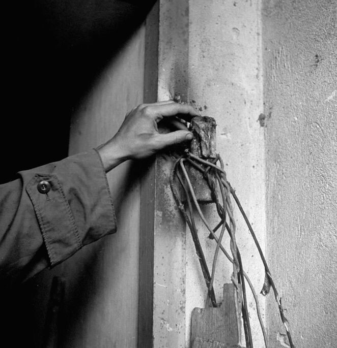 14. Неизвестный касается разрушенной петли двери в бункер Гитлера, сожженной советскими саперами, Берлин, 1945 год.