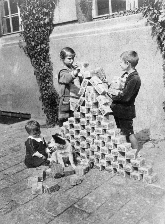 Немецкие дети играют с кучами бесполезных денег благодаря гиперинфляции, 1923 год