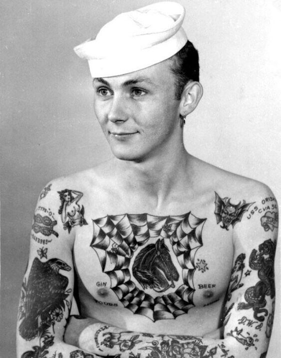 Моряк с гордостью демонстрирует свои татуировки, 1950-е годы
