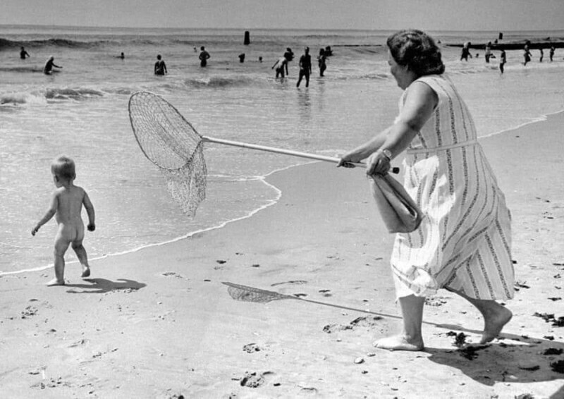 Получившая приз фотография Эда Кларити, на которой женщина ловит ребенка сачком на пляже Рокуэй, 24 августа 1958 года
