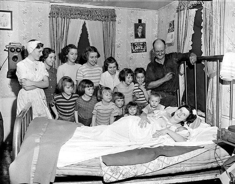 Тринадцать сестер в семье Брукс смотрят на своего единственного брата Лесли Бенджамина после его рождения дома в Питтсфилде, штат Массачусетс, 1954 год