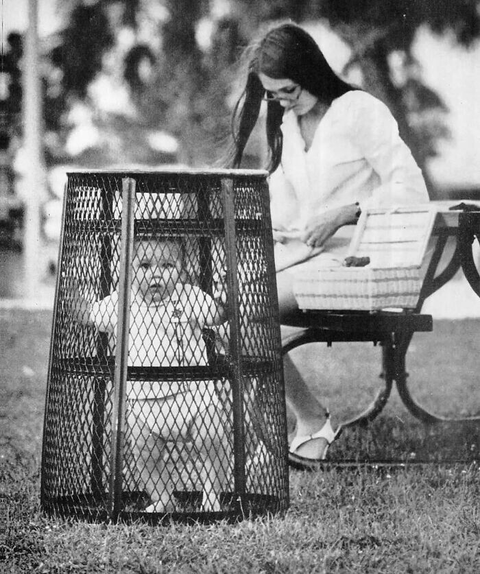 34. Женщина держит ребенка в урне, пока вяжет крючком в парке, 1969 год