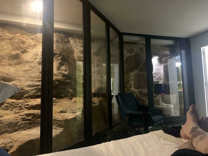 24. "В спальне квартиры, которую я снял на ночь в Порту, Португалия, за стекло помещена стена и лестница 12 века"