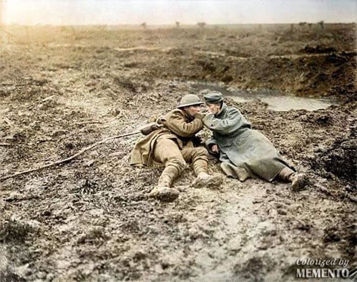 21. Канадский и немецкий солдаты делят на двоих одну сигарету во время второй битвы при Пашендале, ноябрь 1917 года