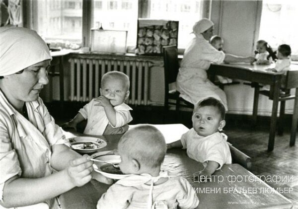 В столовой. Няня кормит малышей. 1930