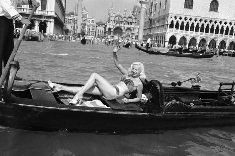 Английская актриса Дайана Дорс плывёт на Венецианский кинофестиваль на гондоле в бикини из норкового меха. 1955 год