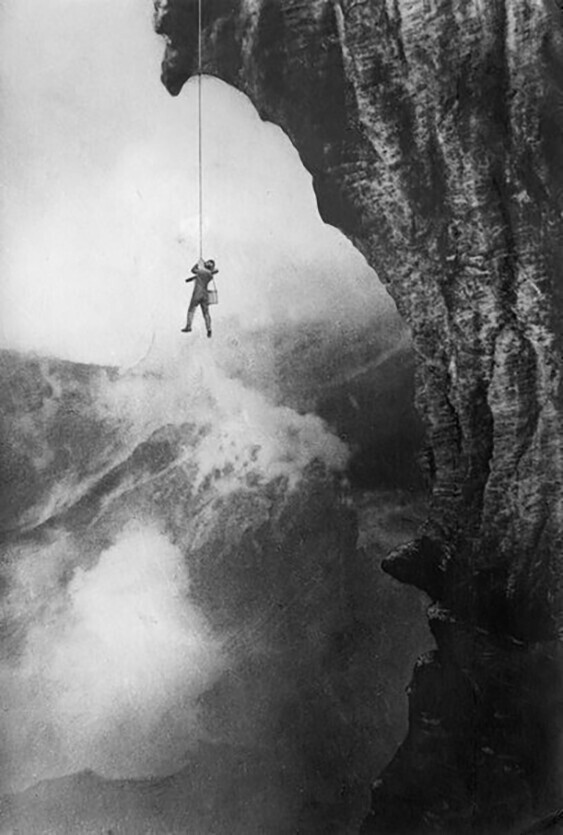 Вулканолог Арпад Кернер висит на веревке над пылающим кратером вулкана Стромболи, 1933 год, Италия