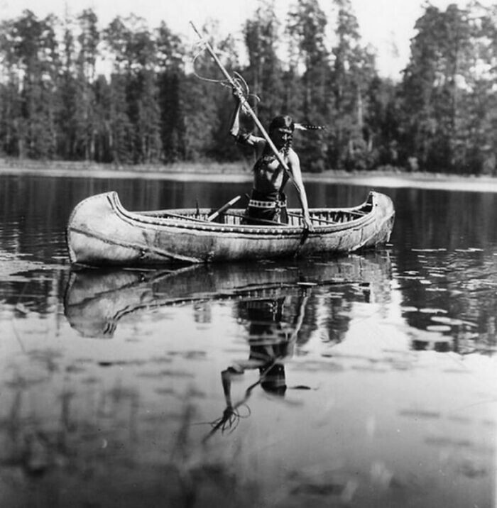 26. Коренной американец из племени оджибве ловит рыбу гарпуном, Миннесота, 1908 год