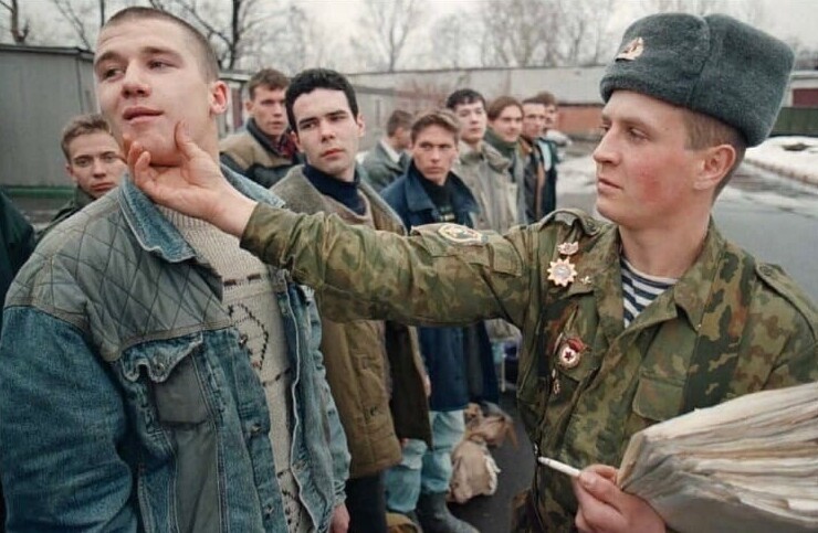 11. Старослужащий учит молодого призывника в одном из военных комиссариатов Москвы. 17 ноября 1995 года