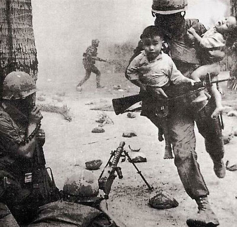 Американский военный спасает вьетнамских детей, вынося с линии огня