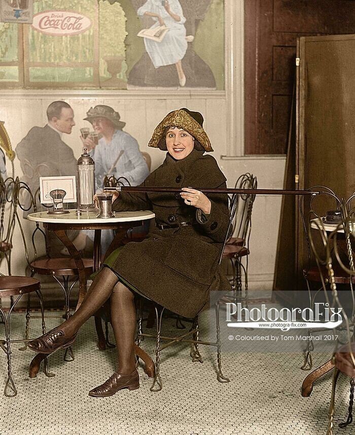 14. [13 февраля 1922] Женщина, сидящая за столом с газировкой, наливает алкоголь в чашку из трости