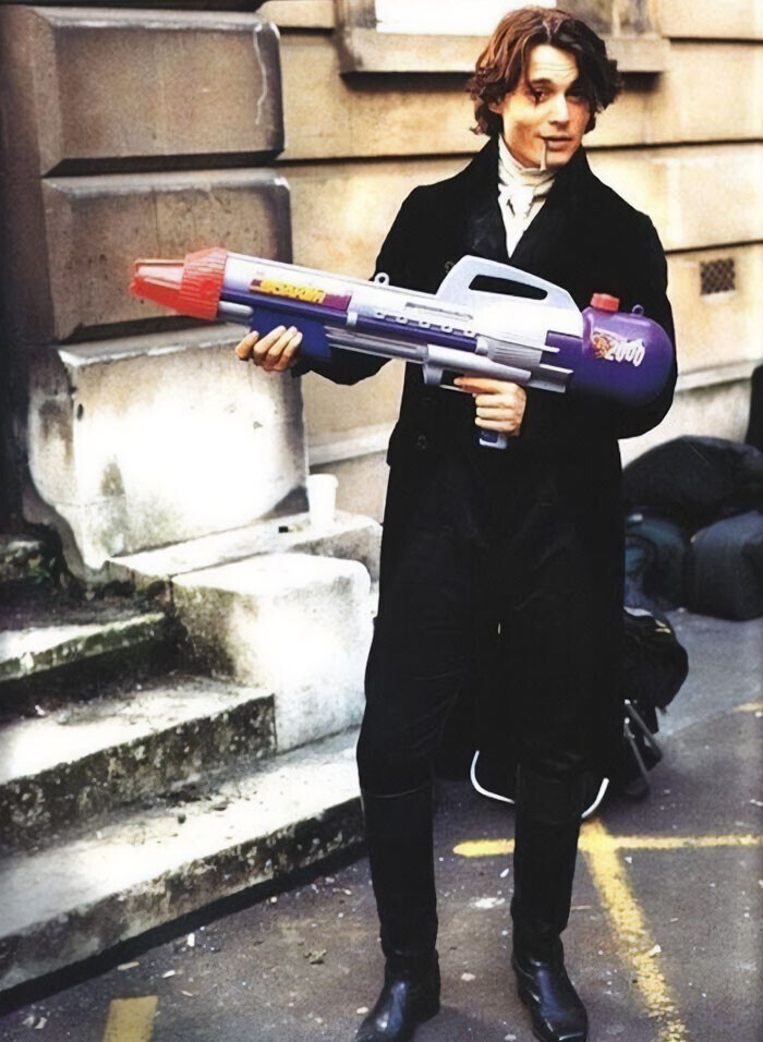 13. Джонни Депп держит в руках игрушечный бластер на съемках «Сонной лощины»