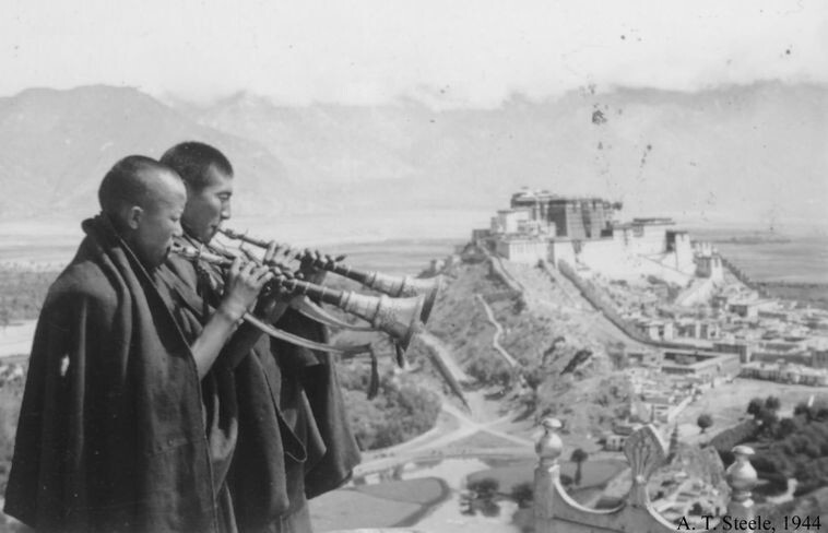 26. Буддийские монахи трубят в призыве к молитве, дворец Потала на фоне, 1944 год