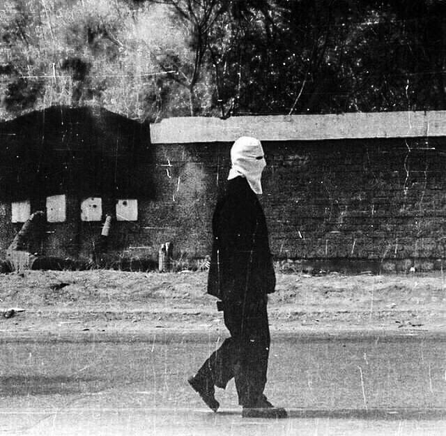 15. Палач проходит мимо расстрельной стены в городе Грозный, Чечня, 1997-98 гг