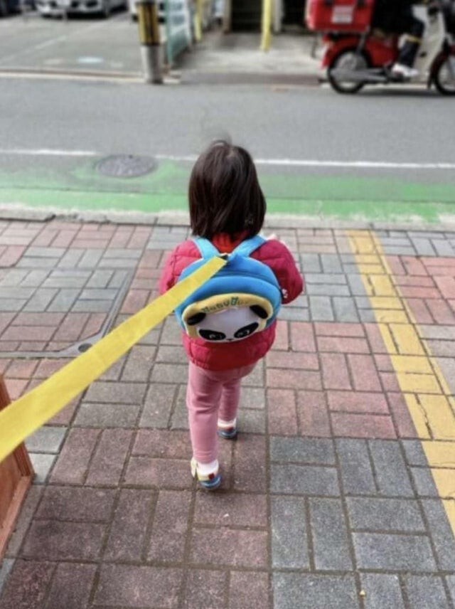 Совершенно типичная прогулка с ребенком для японцев, чтобы обезопасить чадо от выбегания на дорогу
