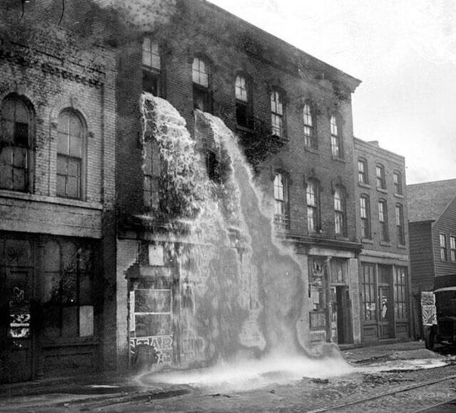 Потоки конфискованного алкоголя льются из окон магазина в Детройте, во времена сухого закона 1929 год