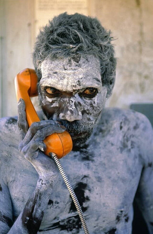 Том Нойтуна, австралийский абориген, впервые использует свой недавно установленный телефон. Это был 1980 год, и фотография была сделана Пенни Твиди