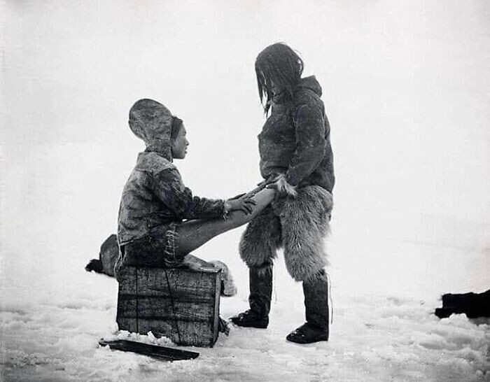 14. Инуит греет ноги жены. Гренландия, 1890-е годы