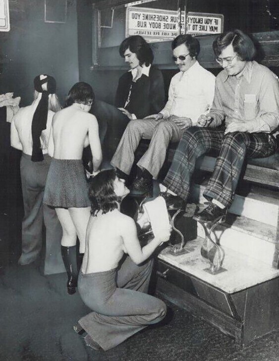 Девушки предоставляют услуги по чистке обуви топлесс. Торонто, 1975 год