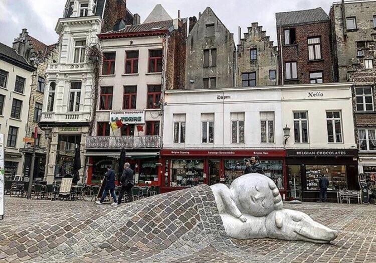 Милая статуя в Бельгии, с мостовой вместо одеяла
