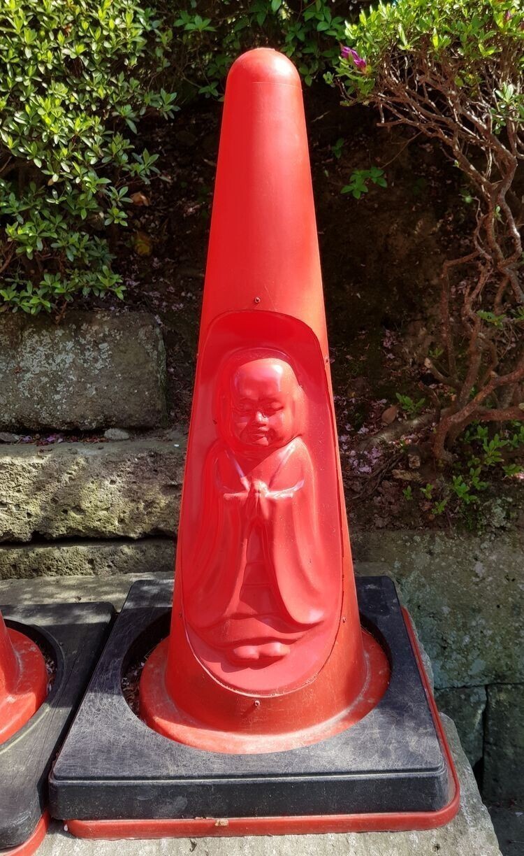 Дорожный конус с изображением Будды, который можно найти в Японии