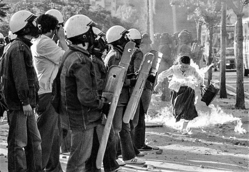 Женщина попала под коктейль Молотова, брошенного во время антиправительственной демонстрации в Университете Данкука. Сеул, Республика Корея, 1988 год