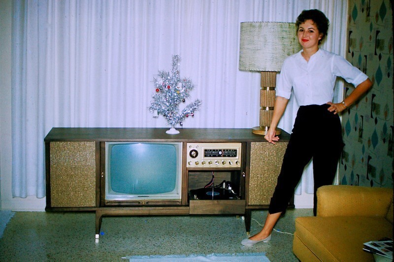 Симпатичная девушка в брюках Капри с музыкальным телекомбайном на Рождество. США, начало 1960-х