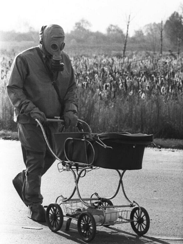 Ребенка, найденного во время ликвидации последствий аварии на Чернобыльской АЭС, везет в коляске ликвидатор, 1986 год
