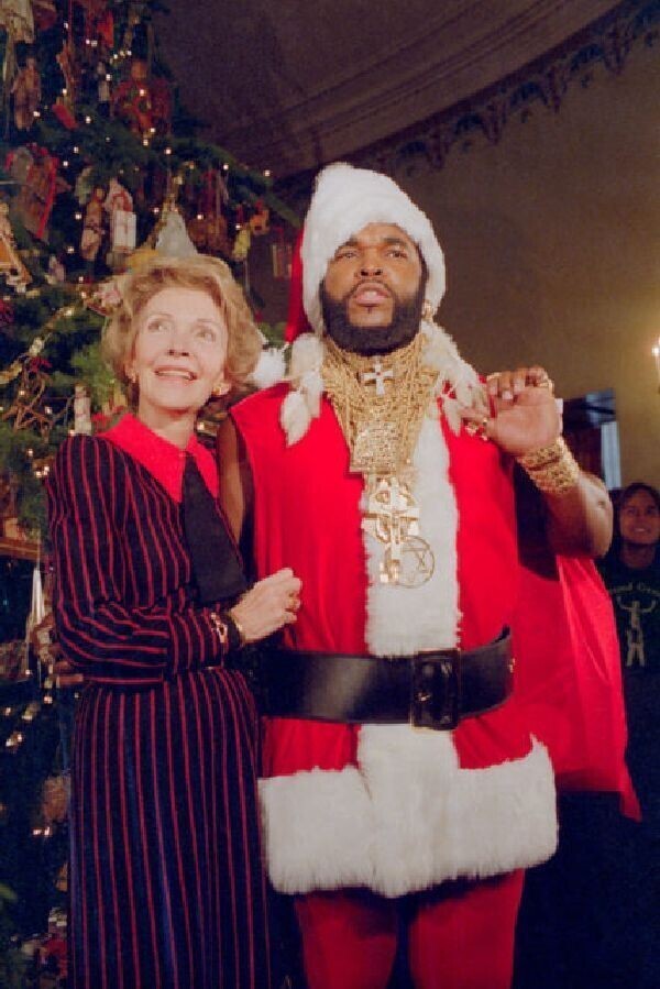 Мистер Ти в костюме Санта-Клауса помогает первой леди Нэнси Рейган представить рождественские украшения Белого дома