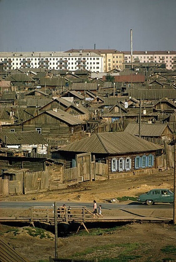 Новые многоквартирные дома возвышаются над старыми избами в Якутске