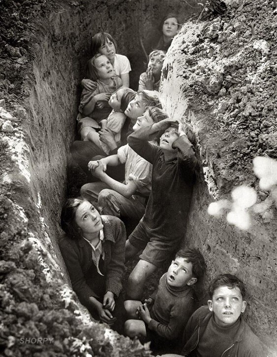 Дети с учительницей прячутся в окопе во время авианалета, Англия, ок. 1941 года