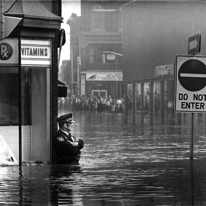Полицейский охраняет аптеку во время наводнения. Канада, 1974