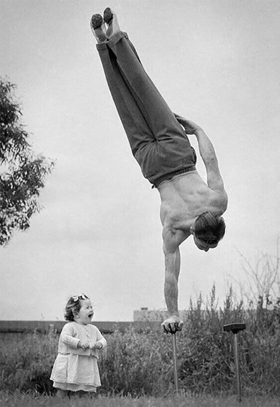 апа показывает гимнастические трюки перед изумленной маленькой дочерью, Мельбурн, Австралия, 1940-е годы