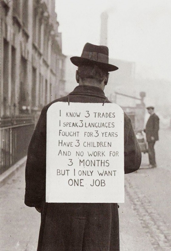 На спине у безработного плакат: "У меня есть 3 профессии, я владею 3-мя языками, я воевал 3 года, у меня 3 детей, уже не работаю 3 месяца и мне всего навсего нужна одна работа."