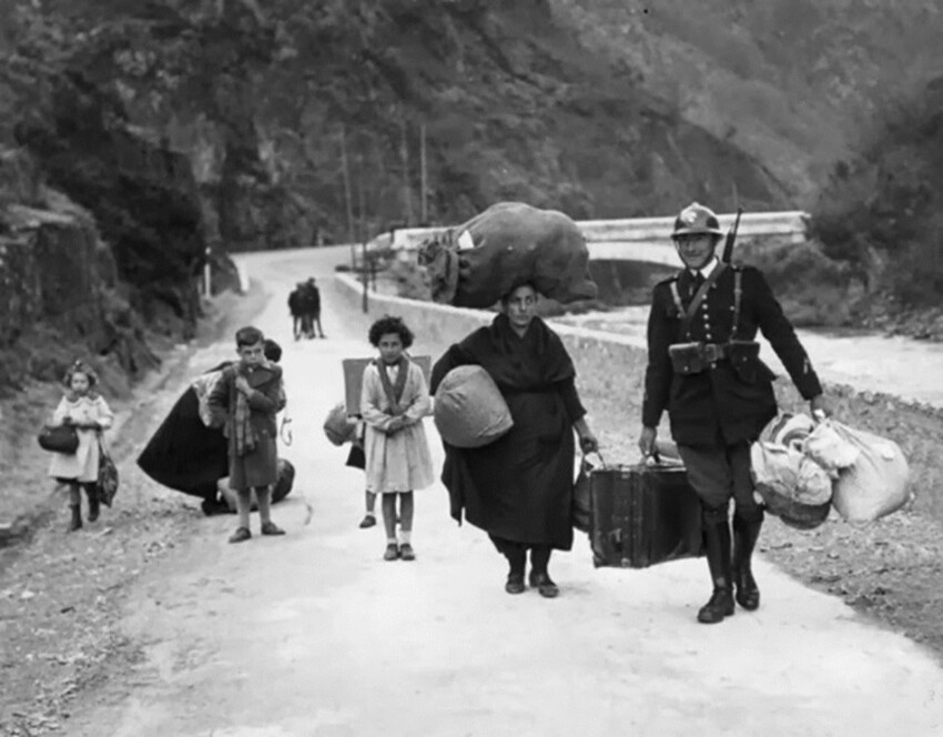 Французский пограничник помогает беженцам с испанской стороны перейти границу во время Гражданской войны в Испании. 1938 год