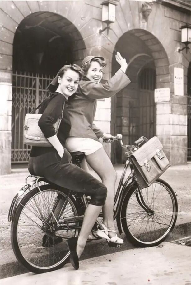 Немецкие школьницы едут домой, ведь на уроки они так и не попали. В школе тогда были запрещены шорты, обтягивающие штаны и посещение её на велосипеде. Германия, 1953 год