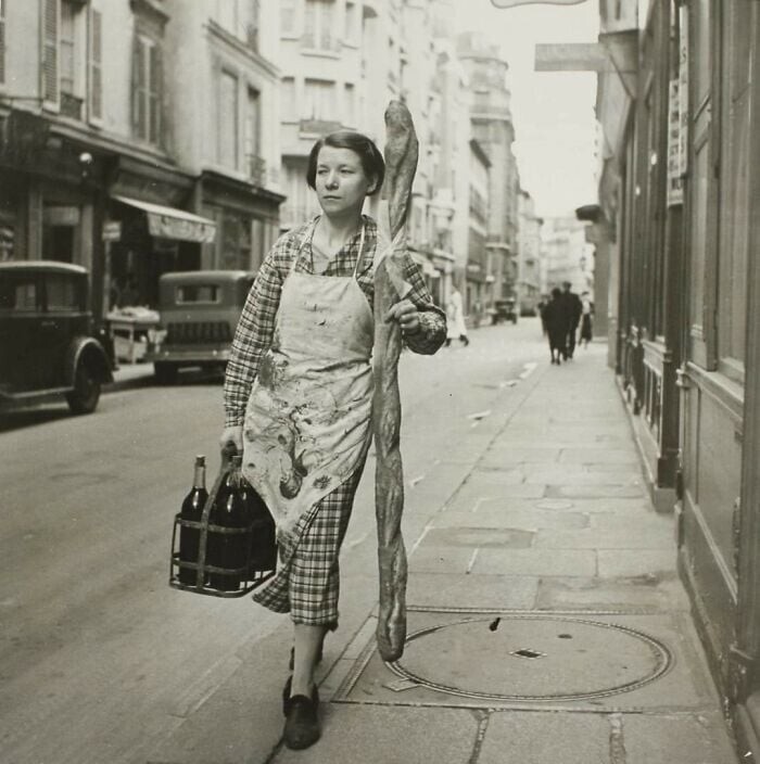 26. Француженка с багетом и шестью бутылками вина на улицах Парижа, 1945 год
