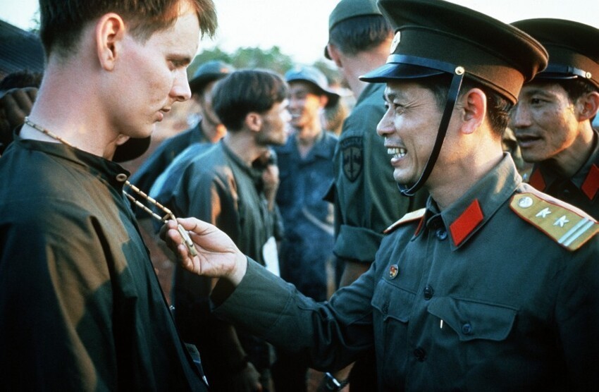 12 февраля 1973 года. Обмен военнопленными в лагере Лок-Нинь. Подполковник Народной армии Вьетнама Буй Тин рассматривает пацифик, висящий на шее Ричарда Спрингмана. Через два года полковник Буй Тин примет капитуляцию правительства Южного Вьетнама.