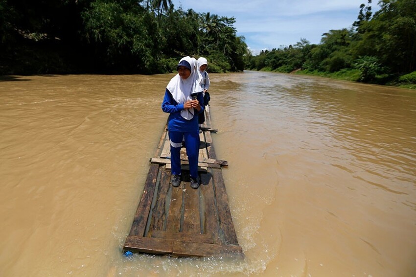 В деревне Чилангкап (Индонезия) приходится пересечь реку Чихеранг на самодельном бамбуковом плоту