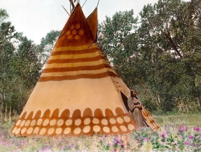 «Типи того, кто делает закат солнца». У входа стоит внучка знахаря. Лагерь черноногих индейцев. Начало 1900-х, фотограф Вальтер МакКлинток