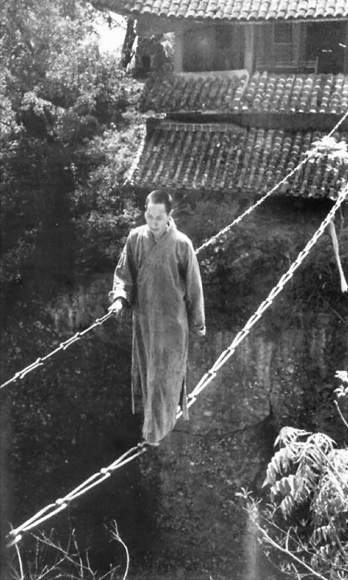 32. 1930-е годы. Китайский буддийский монах идет по цепному мосту в храме Цзянъю-Фиг-Хилл в Китае