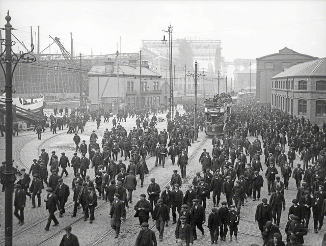 9. Тысячи рабочих покидают верфь после смены. На заднем плане можно увидеть строящийся "Титаник", 1911 год