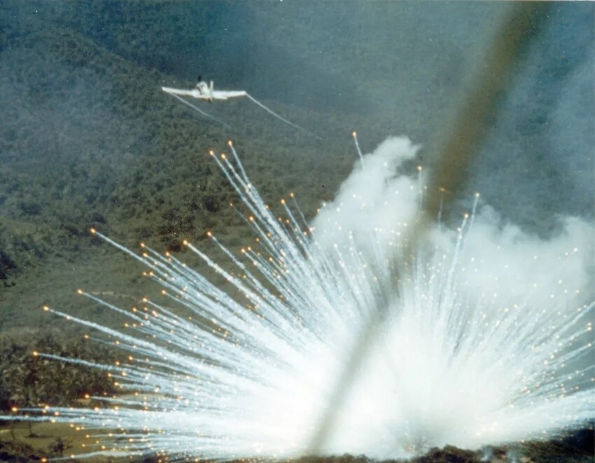Американский штурмовик Douglas A-1 Skyraider сбрасывает бомбы, начиненные белым фосфором, на позиции войск Северного Вьетнама. 1966 год