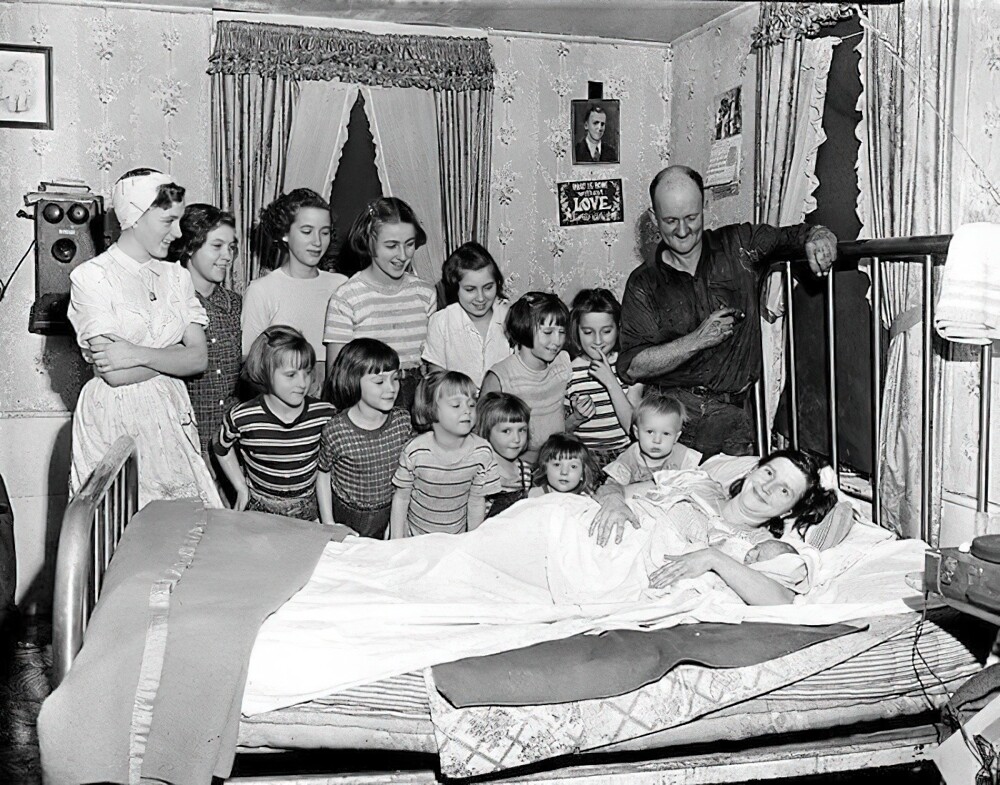 18. Тринадцать сестер из семьи Брукс смотрят на своего единственного брата Лесли Бенджамина после его рождения дома в Питтсфилде, штат Массачусетс, 1954 г.